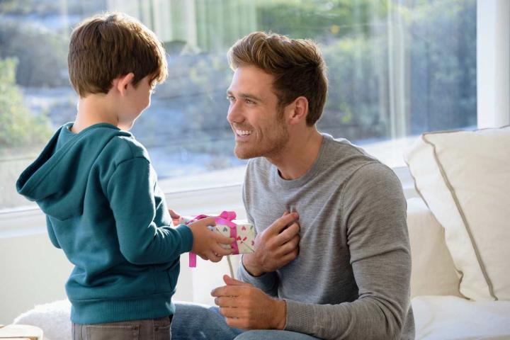 Un niño entregando un regalo a su padre