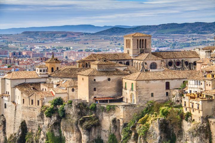 Casco antiguo de Cuenca esculpido en la piedra, con vistas de la parte moderna de la ciudad al fondo.