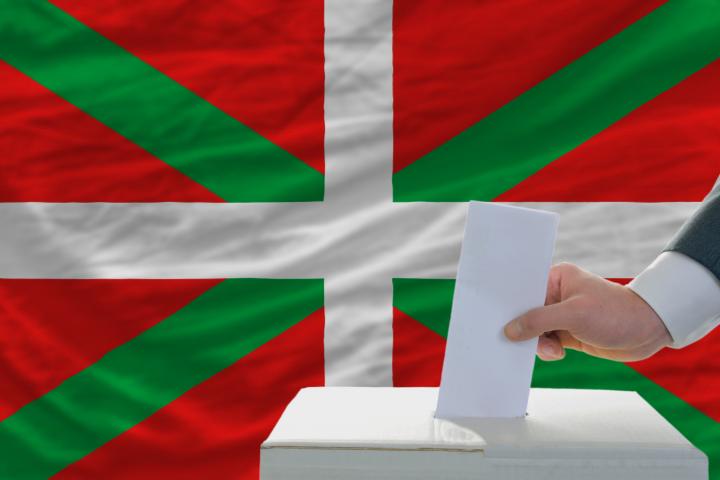 Una bandera del País Vasco con una mesa electoral.