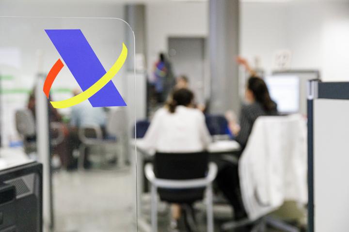 Varias personas en una oficina de la Agencia Tributaria.