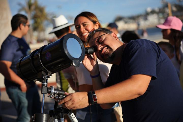 Varios aficionados observan el cielo con un telescopio
