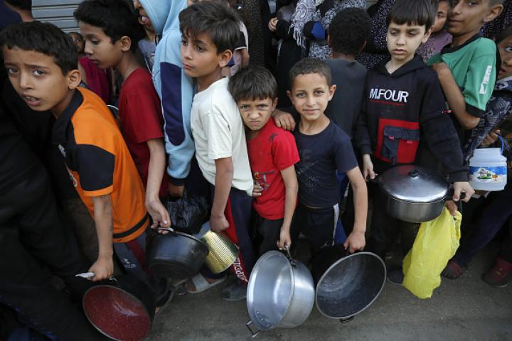 Imagen de archivo de varios niños gazatíes haciendo cola para recibir comida de la escasa ayuda humanitaria que ha logrado llegar a la Franja.
