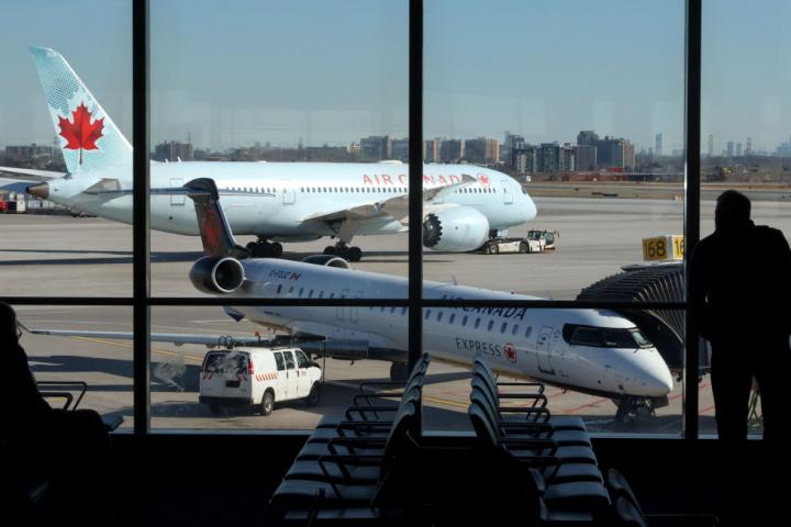 Una persona observa un avión de Air Canadá en el Aeropuerto Internacional Pearson de Toronto.