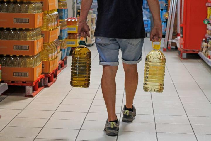 Hombre llevando garrafas de aceite de oliva