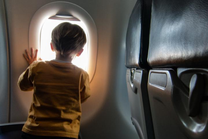 Imagen de archivo de un niño viajando en avión.