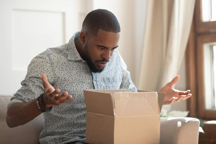 Hombre confuso al abrir su paquete