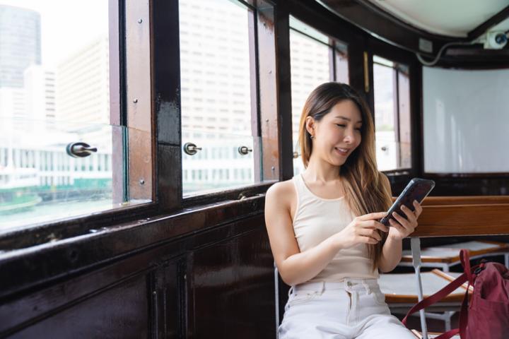 Imagen de archivo de una mujer comprobando su 'smartphone' en un barco.