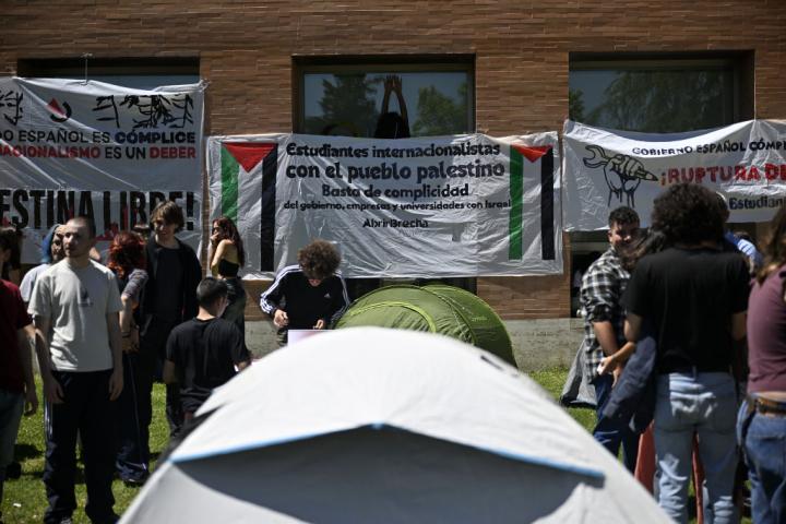 Manifestantes con tiendas de campañas, banderas y pancartas en el campus de la Universidad Complutense