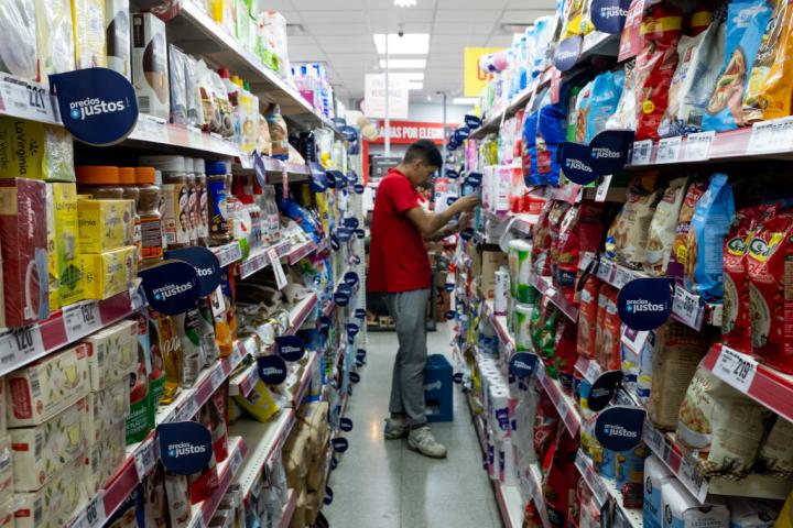 El trabajador de un supermercado en Argentina coloca varios productos en las estanterías.