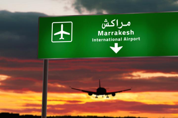 Ilustración de la silueta de un avión volando hacia Marrakech (Marruecos) en el horizonte.