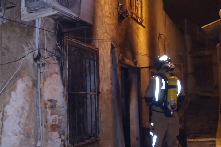 Uno de los bomberos desplazados al incendio en la vivienda de Ricote (Murcia), donde han fallecido tres personas.
