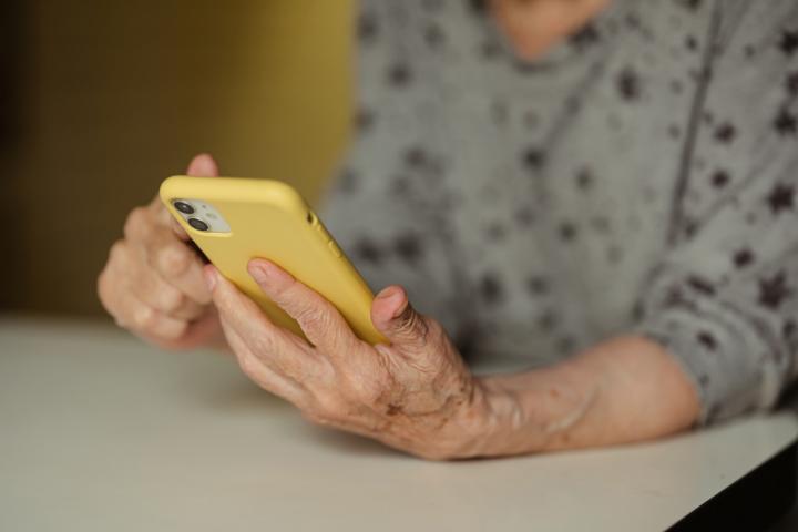 Foto de archivo de una mujer anciana mandado un WhatsApp.