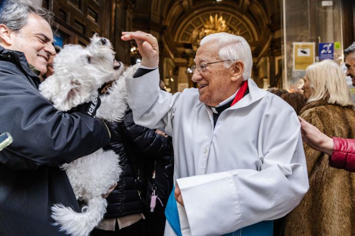 El Padre Ángel saluda a un perro tras celebrarse la misa de San Antón en Madrid.