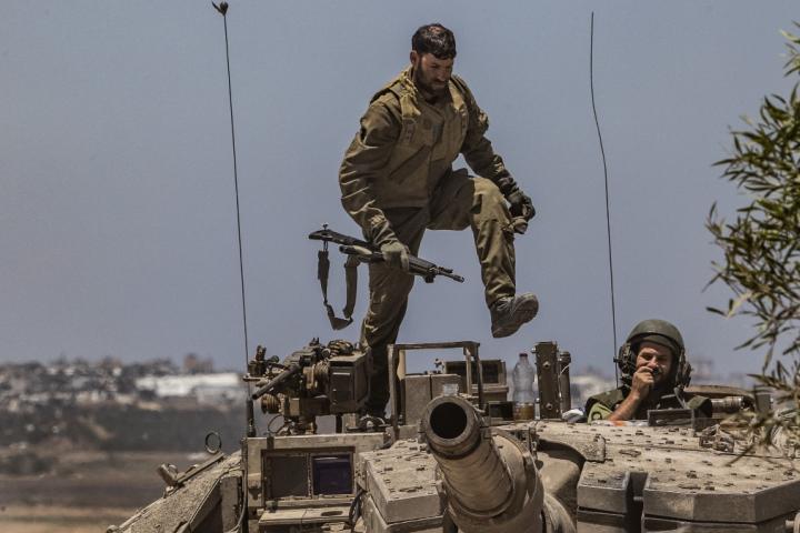 Soldado israelí controlando un tanque mientras continúa la movilización militar del ejército israelí cerca de la frontera de Gaza