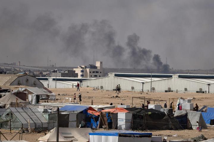 Imagen de archivo de una columna de humo vista desde un centro de desplazados en Rafah (Franja de Gaza), tras un ataque israelí.