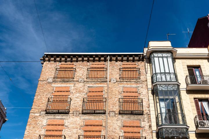 Antiguo edificio residencial con ventanas tapiadas para evitar la entrada de okupas.