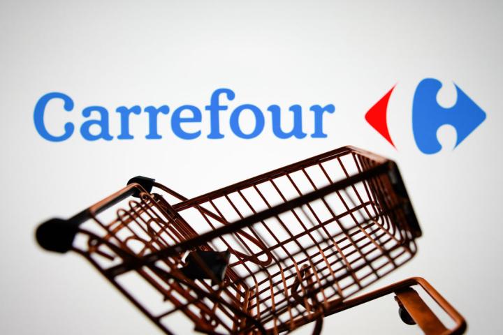 El logotipo de Carrefour, detrás de un carro de la compra.
