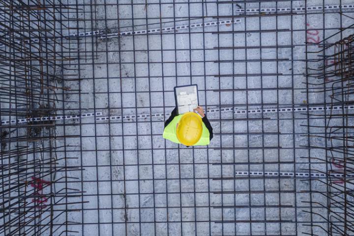 Imagen de archivo de un operario en una obra, sobre los cimientos, visto desde arriba.