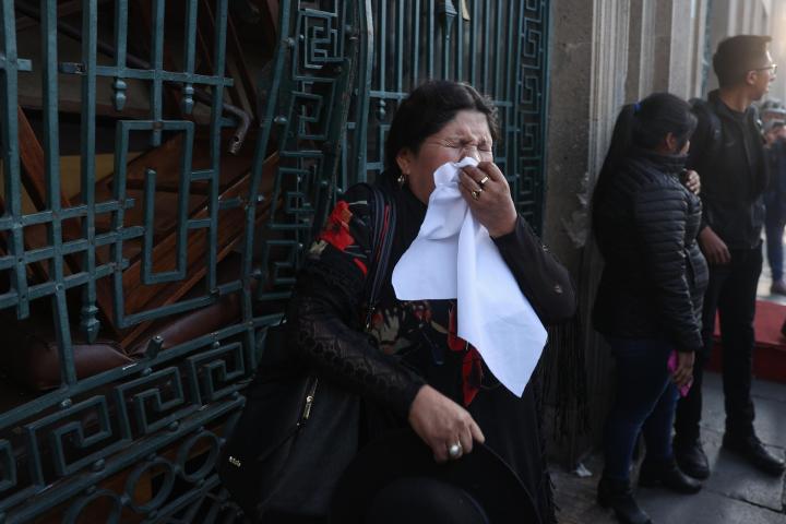 Una mujer se protege de los gases lacrimógenos lanzados durante la movilización social contra el intento de golpe de Estado en Bolivia.