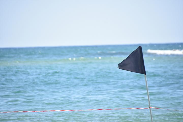 Bandera negra en una playa.