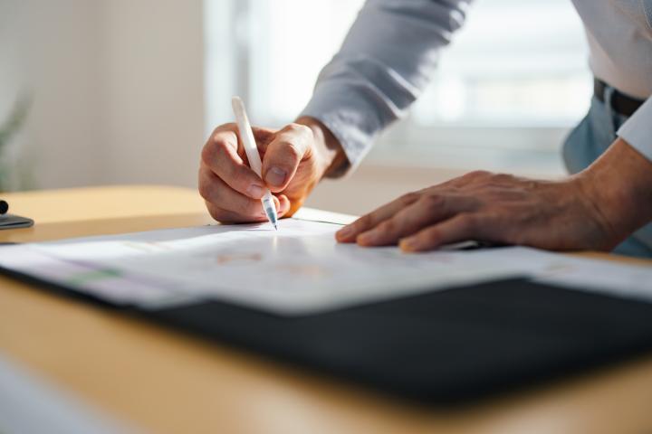 Una trabajador firmando unos papeles.