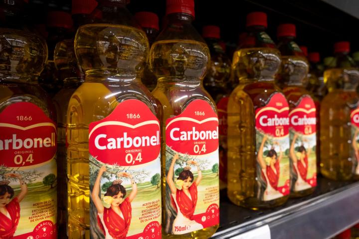Botellas de aceite de oliva de la marca Carbonell, en el lineal de un supermercado.
