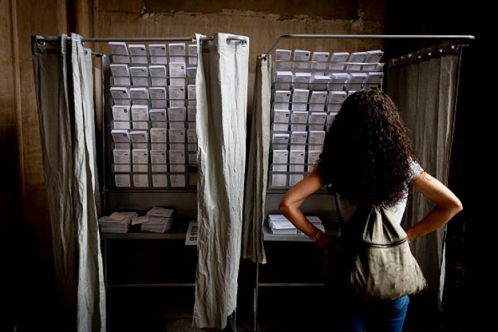 Imagen de archivo de una mujer ante una cabina de votación de las elecciones europeas del 9J, en Barcelona.