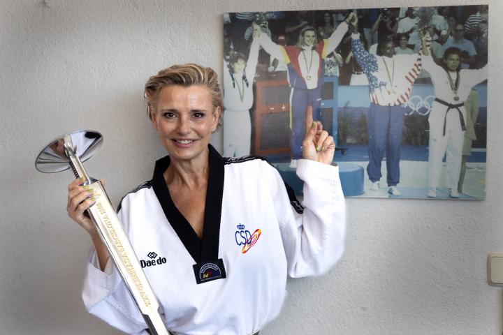 La Coral Bistuer posa con la antorcha olímpica de Barcelona 1992 junto a su foto en el podio