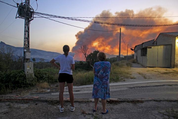 Dos personas observa el incendio de Benasau (Alicante)