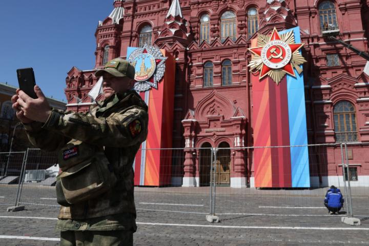 Un militar con el signo "Z", símbolo de la invasión militar rusa de Ucrania, se hace un selfie junto a las decoraciones del Día de la Victoria, cerca del Kremlin, en Moscú.