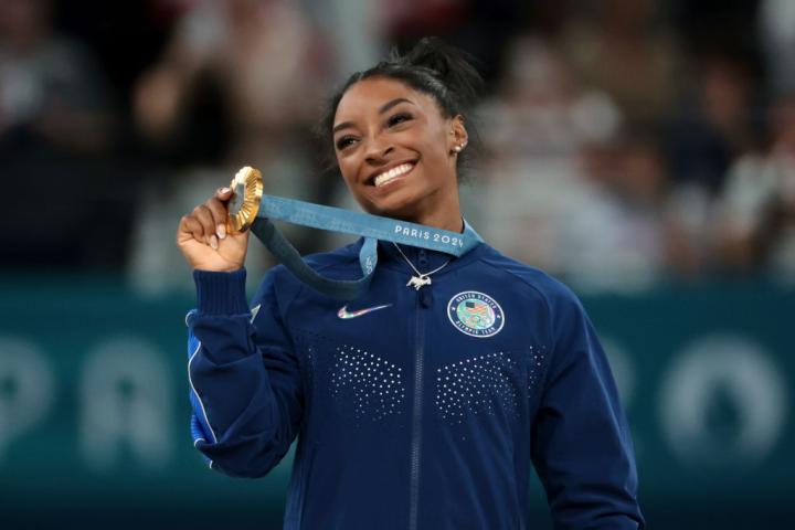 Simon Biles feliz con su medalla de oro en el concurso completo femenino de gimnasia artística.