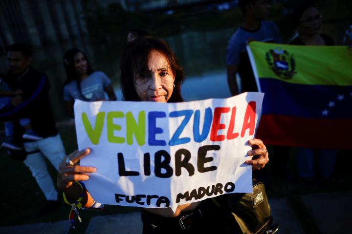 Una mujer sostiene un cartel contra Nicolás Maduro en las protestas contra los resultados de las presidenciales en Venezuela
