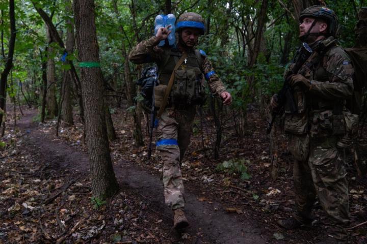 Soldado ucraniano cargando botellas de agua