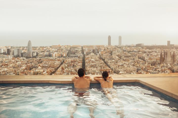 Una pareja se relaja en la azotea de un hotel de Barcelona mirando el skyline de la ciudad