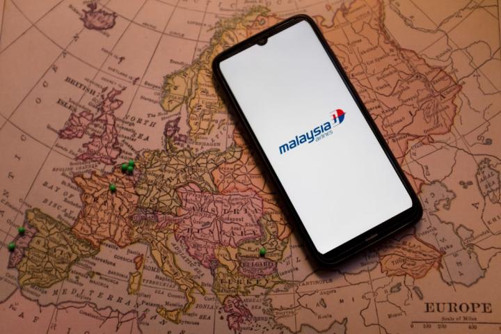 Ilustración del logo de Malaysia Airlines sobre un mapamundi.