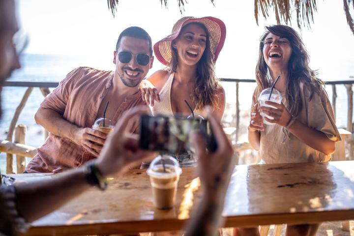Imagen de un grupo de amigos tomándose una foto en un chiringuito de playa.