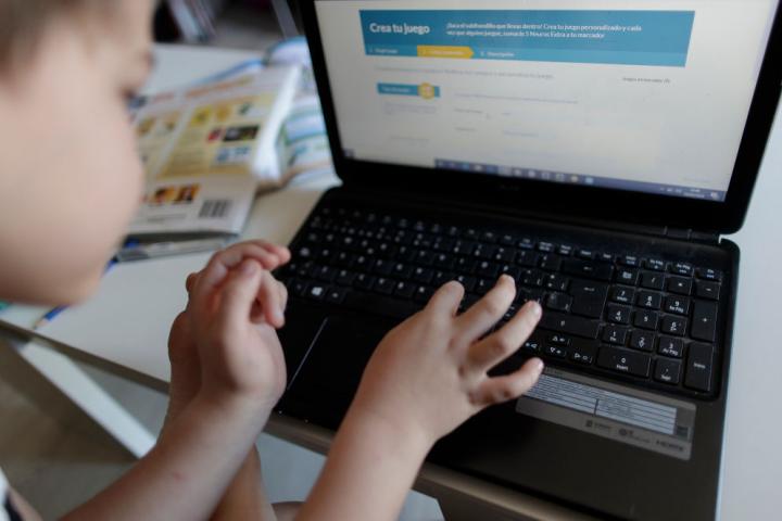 Un niño hace deberes del colegio en su ordenador
