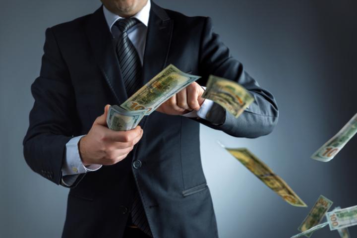 Un millonario lanza al aire billetes de dólar.