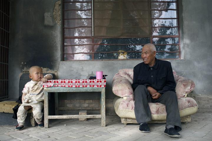 Imagen de archivo de un niño y un anciano mirándose, en DunHuang (China).