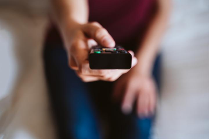 Imagen de archivo de una persona con un mando a distancia.