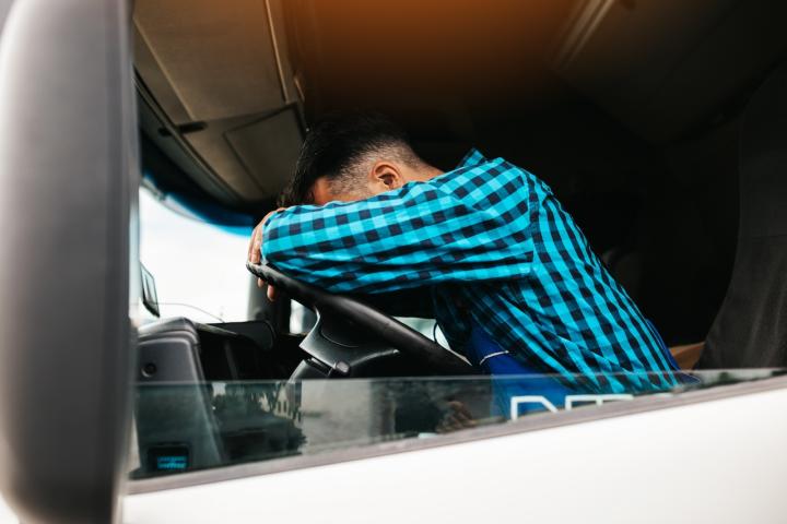 Un conductor, cansado y somnoliento, durmiendo en su camión.