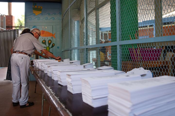 Imagen de archivo de varias personas ante las papeletas de las elecciones generales del 23J en la Escola Mercè Rodoreda, en Barcelona.