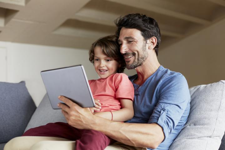 Padre con su hija usando una tablet.