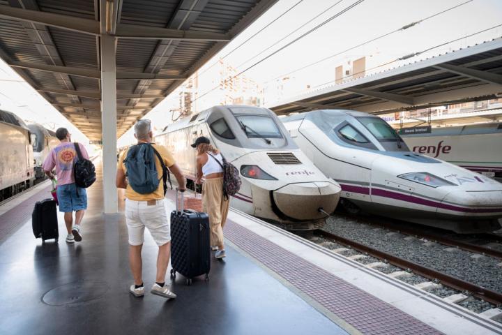 Un grupo de pasajeros se dirige a un tren de Renfe estacionado en la estación de Alicante.