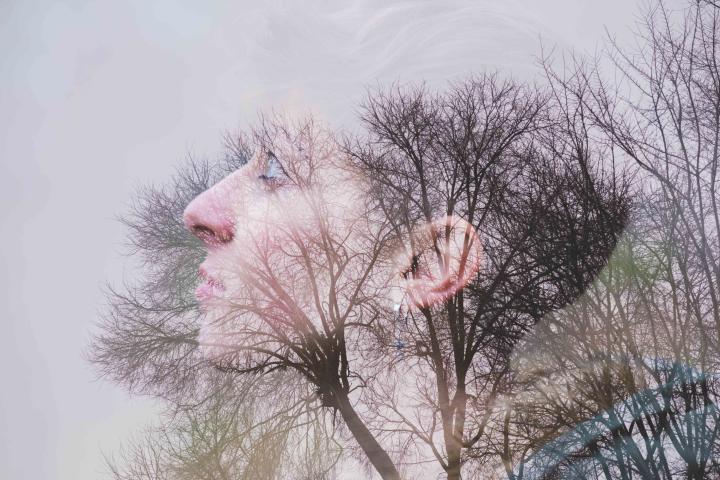 Mujer joven, vista lateral y árboles.