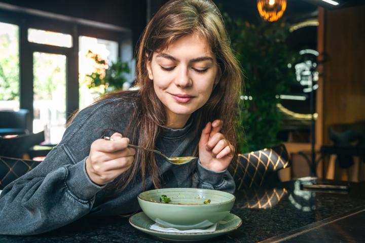 Mujer tomando un plato de sopa