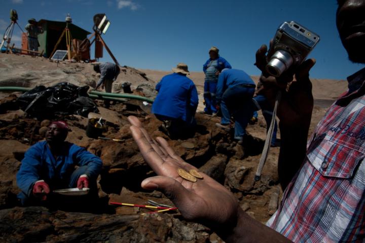 Una persona sostiene algunas de las monedas halladas.