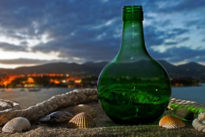 Imagen de archivo de una botella cristal ante el mar.