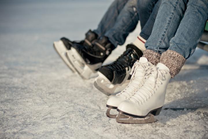 Dos personas preparándose para patinar sobre hielo.