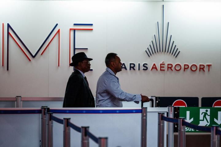 Dos viajeros, en la cola para pasar un control de seguridad en un aeropuerto de París